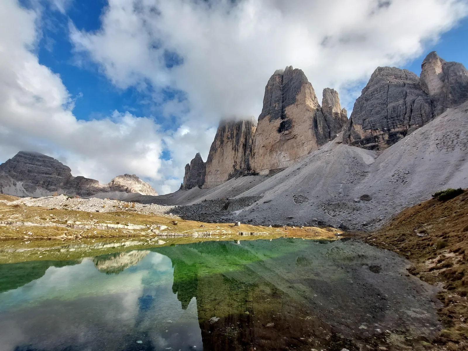 Tre Cime reflected in a small tarn on the loop trail