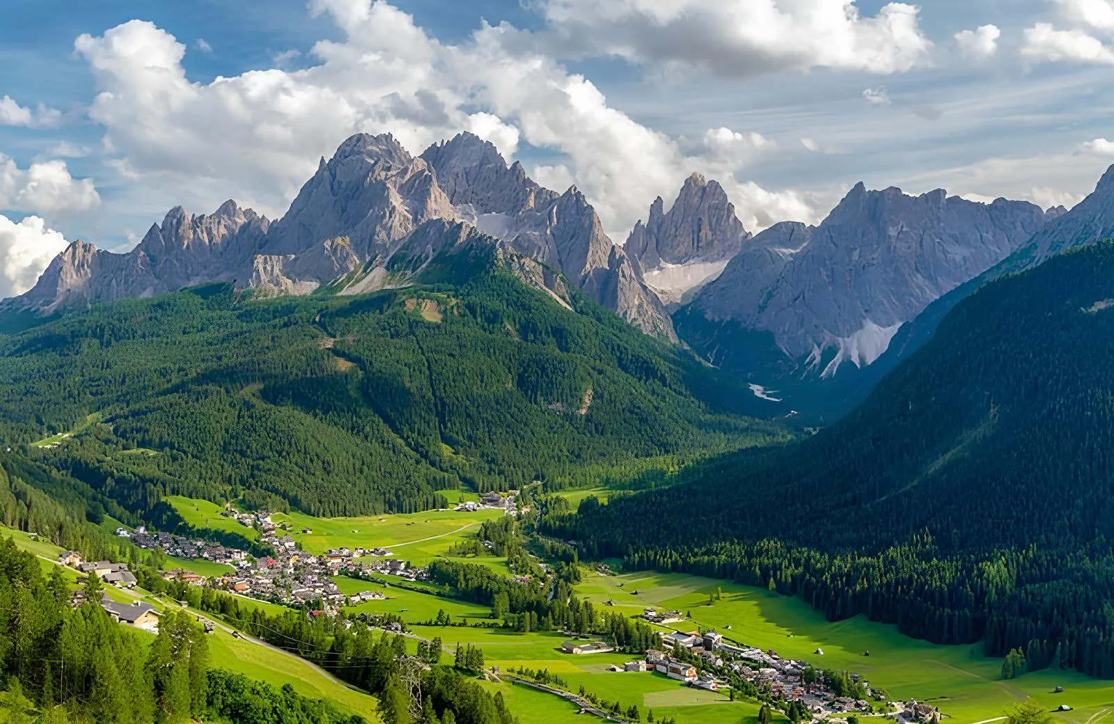 Dolomites valley with a village below jagged peaks