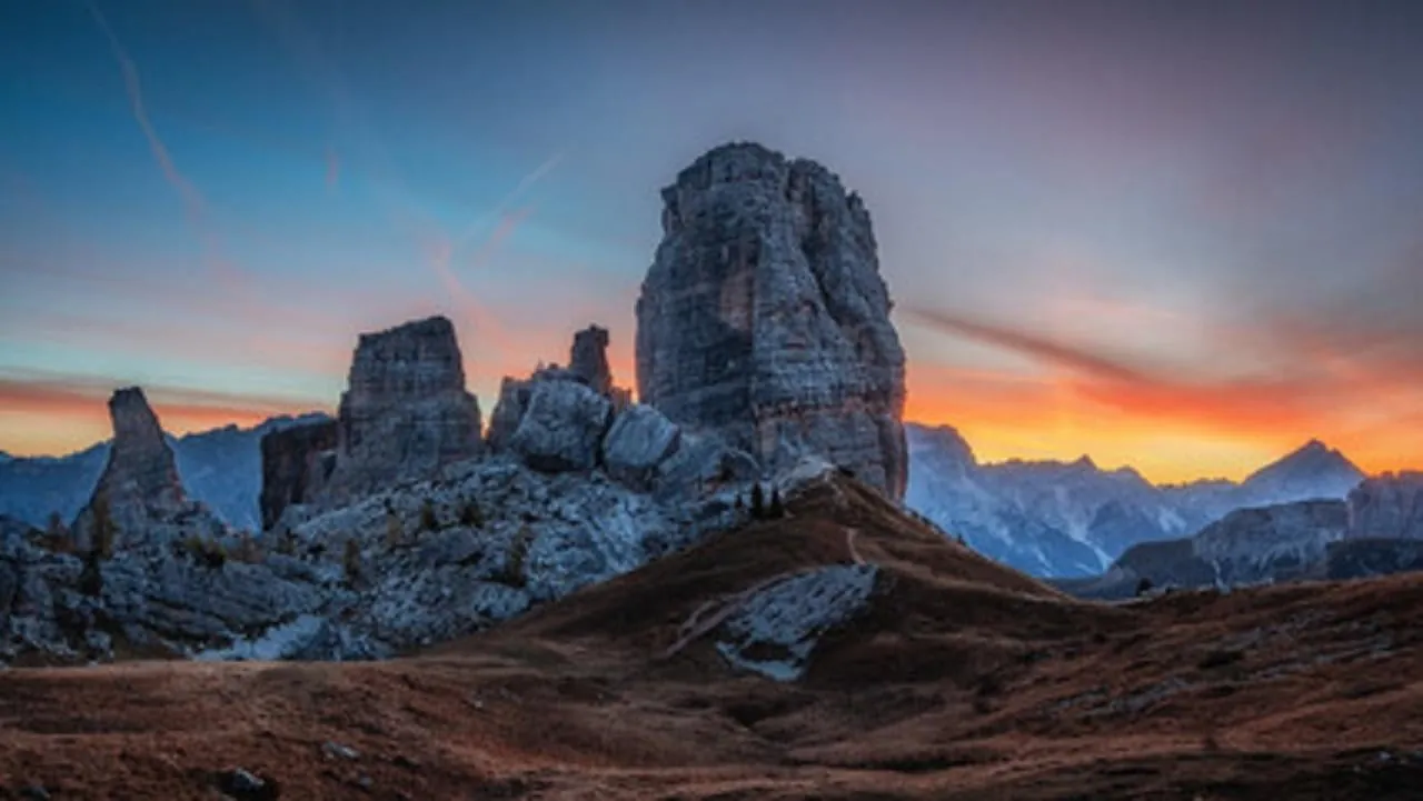 The Cinque Torri silhouetted against an orange sunset