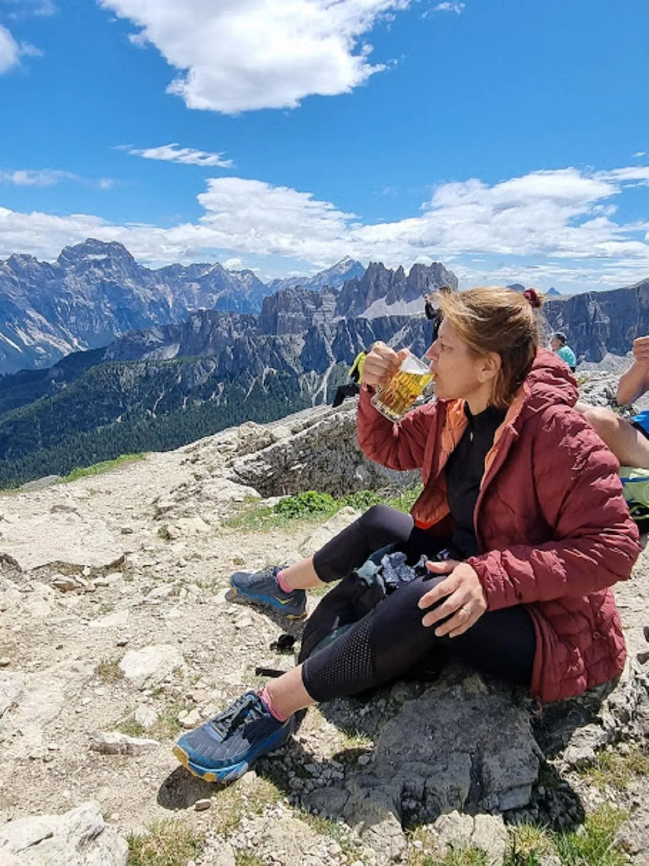 Hiker resting on the rocks with the Dolomites spread out behind